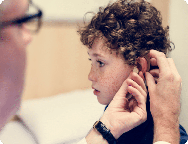 A young boy using cochlear implants to be able to hear clearly.