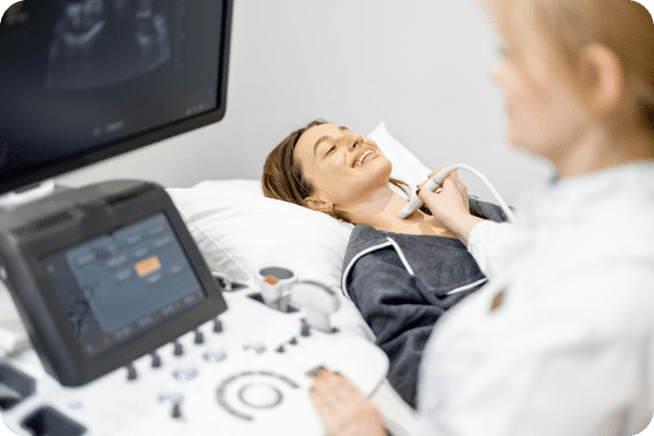 Performing ultrasound around the patient's neck.