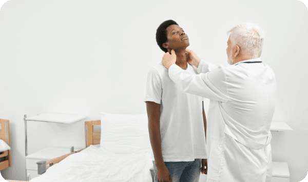 A doctor checking his patient around the neck.