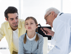 A young patient being checked by audiologist to detect hearing prpoblems.
