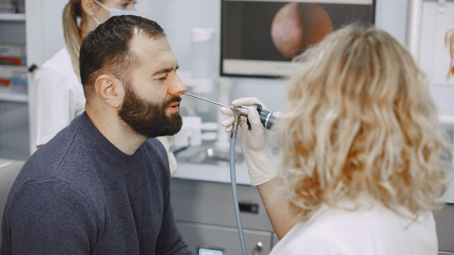 A mature guy getting his nose examined for nasal polyps