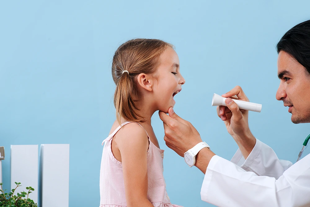A throat doctor checking a child patient carefully.