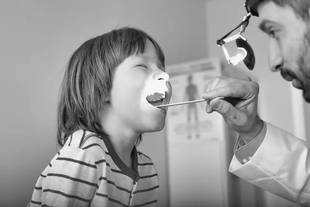A throat specialist checking a child's throat.