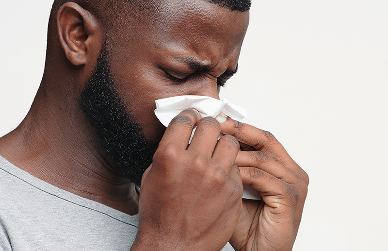 Man blowing his nose from nasal obstruction